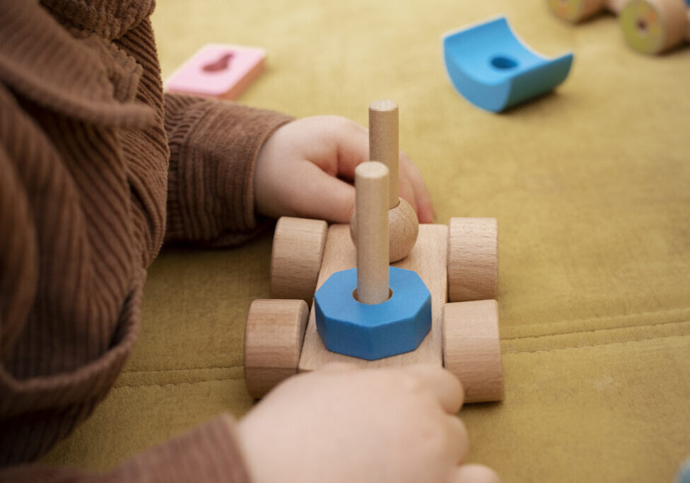 close-up-kid-holding-wooden-toy